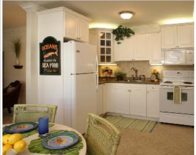 735 Hummingbird Way, Unit 202 North Palm Beach, FL 33408 - Photo 5 of 15 a kitchen with a refrigerator and cabinets