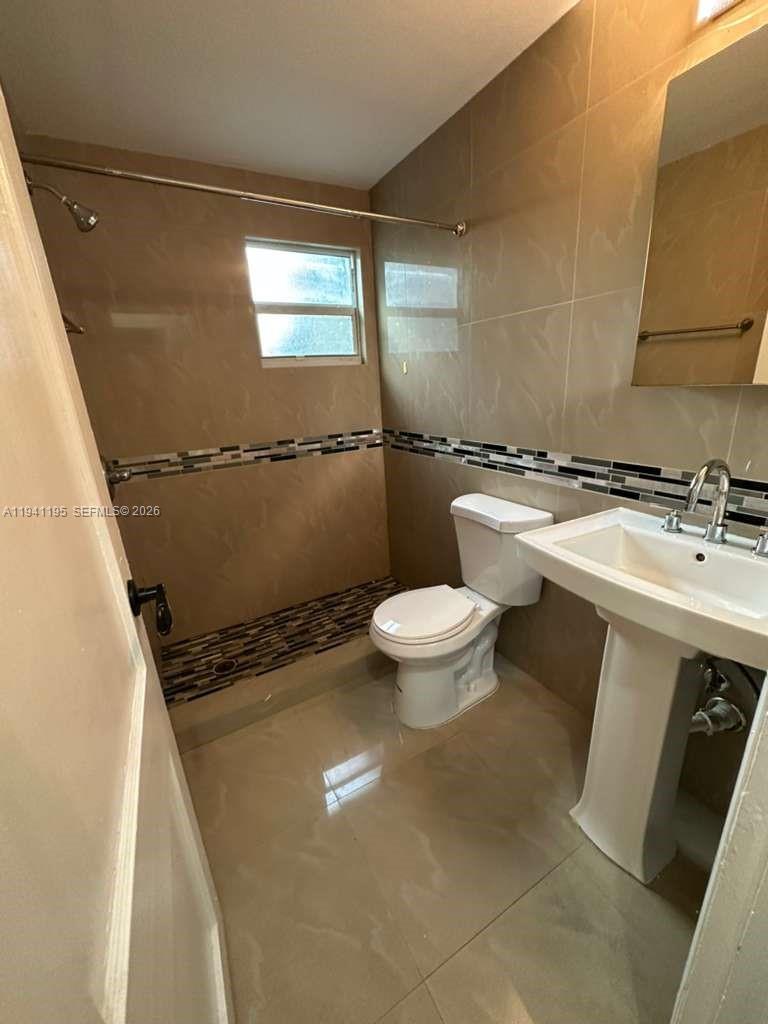 920 Northwest 22nd Court, Unit 920 Miami, FL 33125 - Photo 12 of 28 a bathroom with a sink a toilet and a mirror