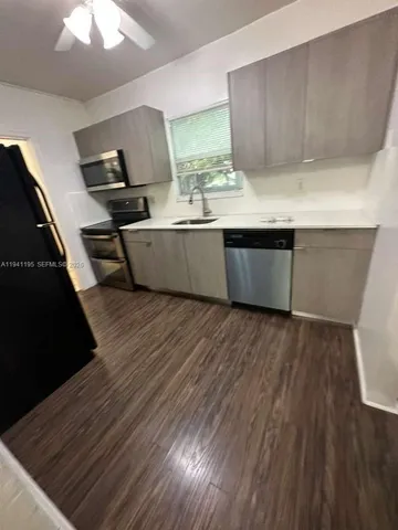 a view with kitchen island wooden floors wooden cabinets