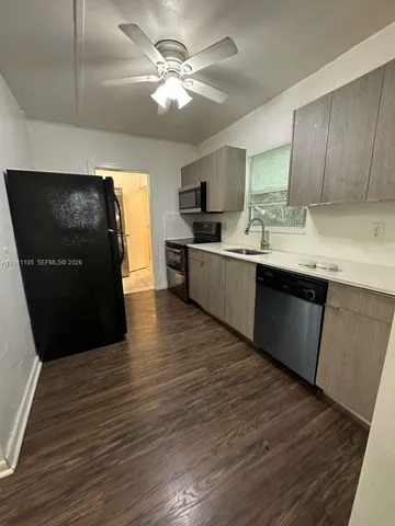 a kitchen with stainless steel appliances granite countertop a sink a stove top oven and wooden floors
