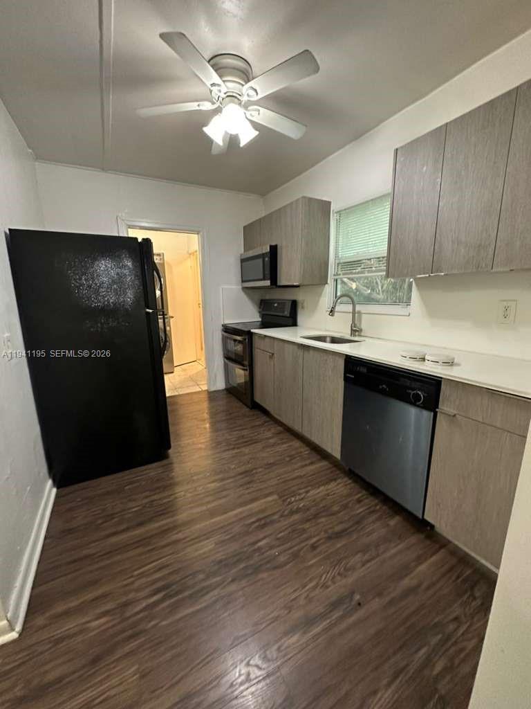 920 Northwest 22nd Court, Unit 920 Miami, FL 33125 - Photo 16 of 28 a kitchen with stainless steel appliances granite countertop a sink a stove top oven and wooden floors