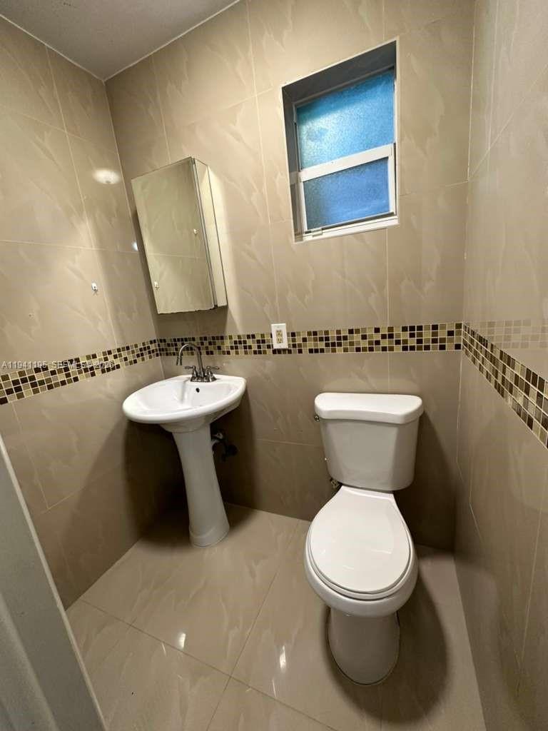 920 Northwest 22nd Court, Unit 920 Miami, FL 33125 - Photo 20 of 28 a bathroom with a toilet sink and mirror