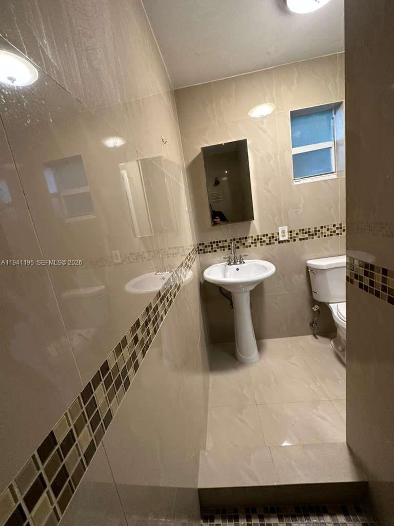 920 Northwest 22nd Court, Unit 920 Miami, FL 33125 - Photo 21 of 28 a bathroom with a sink a toilet and mirror