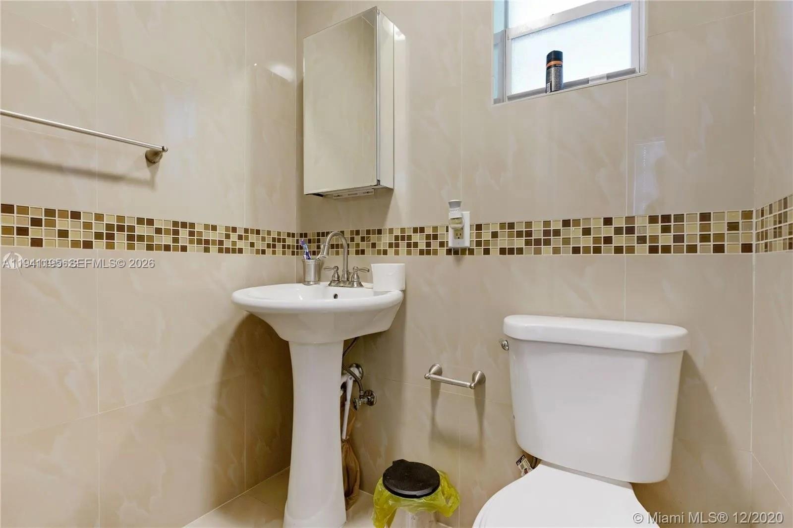 920 Northwest 22nd Court, Unit 920 Miami, FL 33125 - Photo 25 of 28 a bathroom with a toilet a sink and a mirror