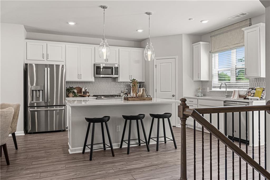 66 Wilder Ridge Way Lawrenceville, GA 30044 - Photo 14 of 44 a kitchen with stainless steel appliances granite countertop a refrigerator a sink dishwasher a stove and white cabinets with wooden floor
