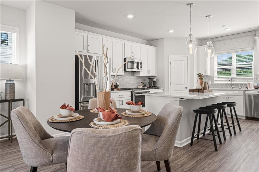 66 Wilder Ridge Way Lawrenceville, GA 30044 - Photo 15 of 44 a kitchen with a dining table chairs and white appliances