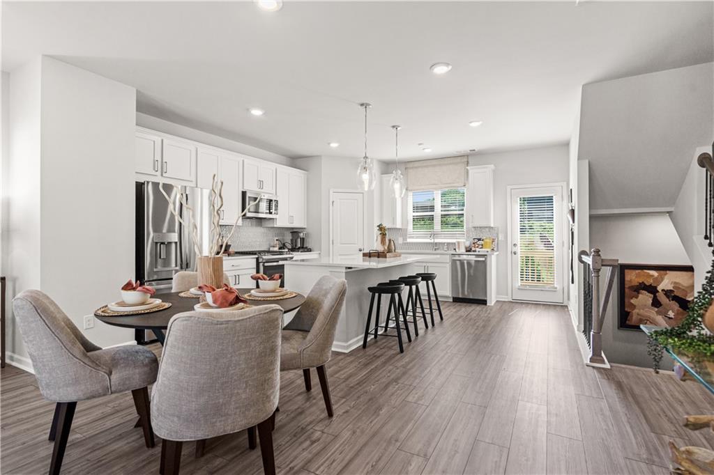 66 Wilder Ridge Way Lawrenceville, GA 30044 - Photo 16 of 44 a dining room with stainless steel appliances kitchen island granite countertop a table chairs and a refrigerator