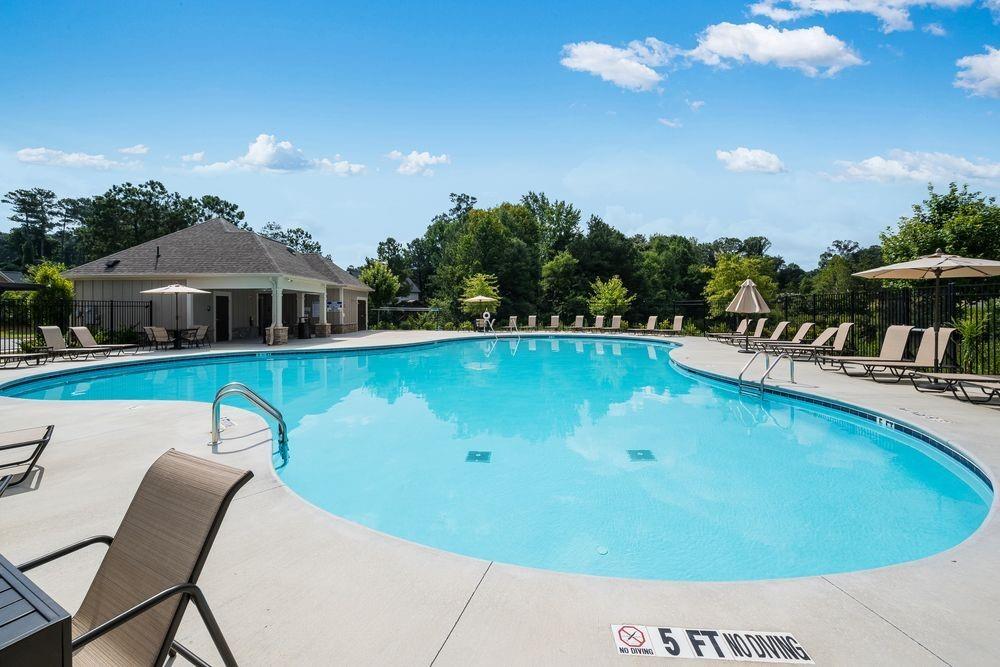 66 Wilder Ridge Way Lawrenceville, GA 30044 - Photo 40 of 44 a view of a swimming pool with lawn chairs under an umbrella