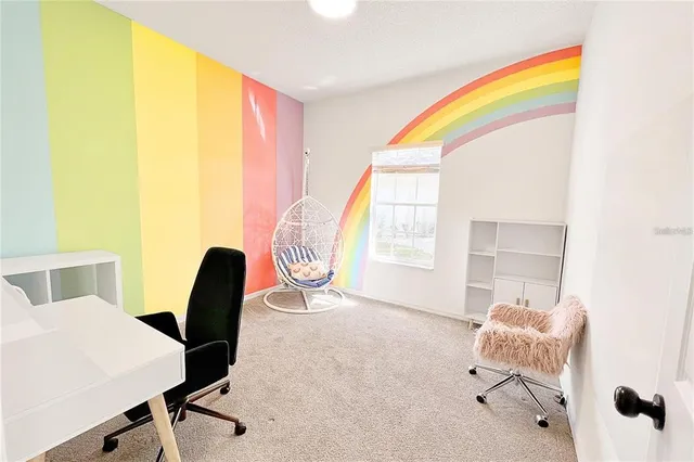 a view of a workspace with furniture and a window