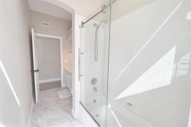 a bathroom with a shower and a glass door