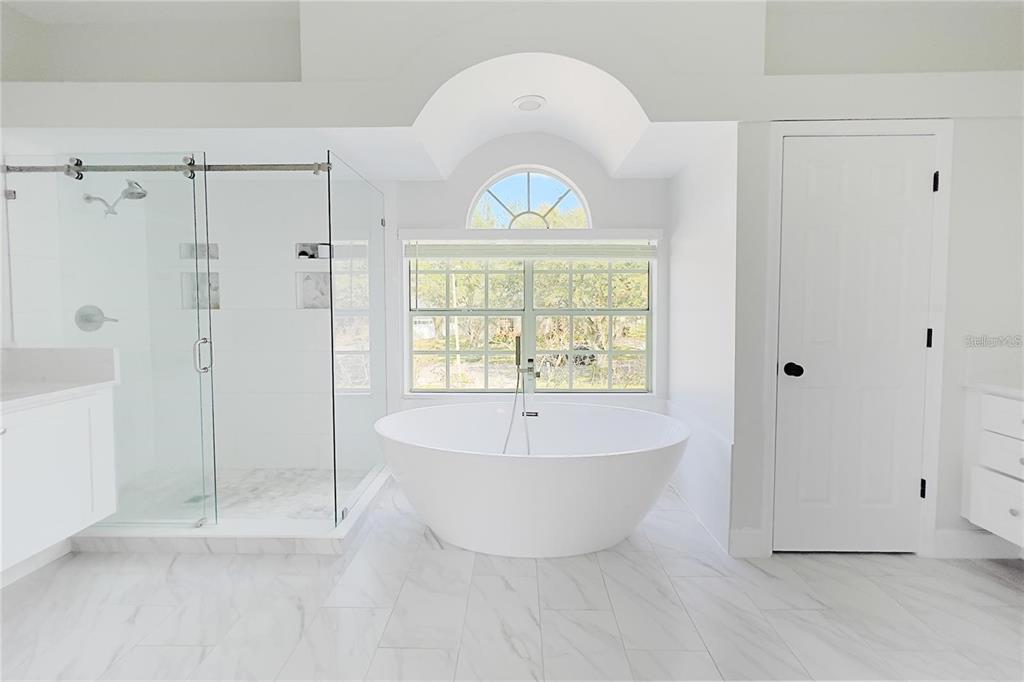 3273 Furlong Way Gotha, FL 34734 - Photo 28 of 38 a bathroom with a white tub shower and window