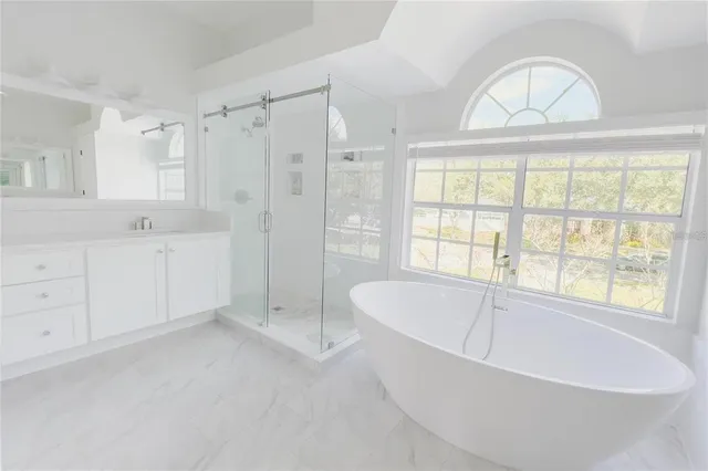 a spacious bathroom with a tub shower and window