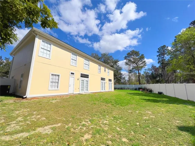 a large house with a big yard and large trees