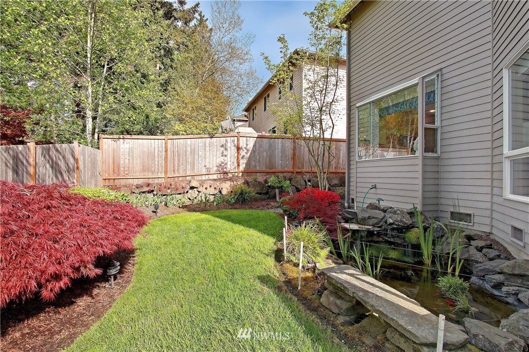 2019 237th Place Southeast Bothell, WA 98021 - Photo 9 of 26 a backyard with potted plants and a wooden bench