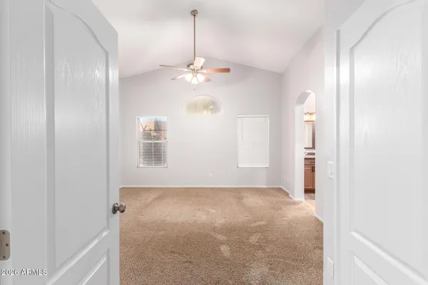 an empty room with windows and fan