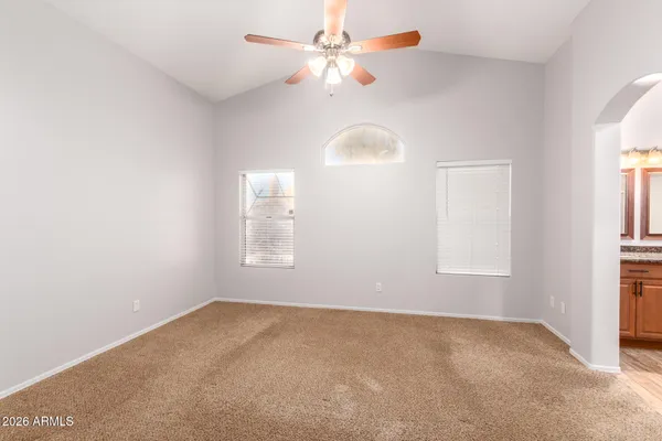 an empty room with closet and a chandelier fan