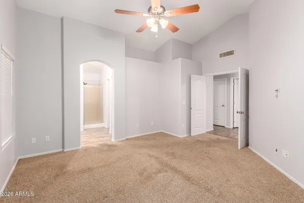 an empty room with closet and a chandelier fan