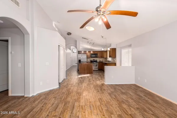 a kitchen with stainless steel appliances granite countertop a stove a sink dishwasher a refrigerator and a oven with wooden floor