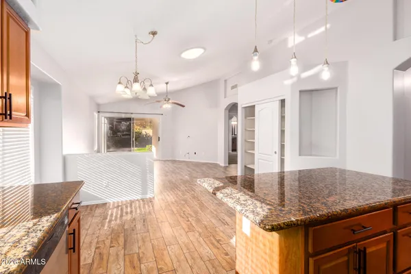 a kitchen with stainless steel appliances granite countertop a sink a stove a refrigerator cabinets and a window