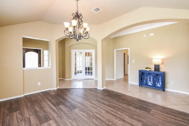 a view of a big room with wooden floor and chandelier