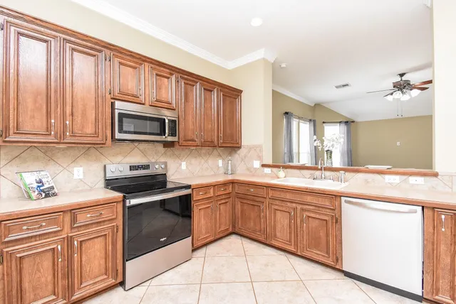 a kitchen with stainless steel appliances granite countertop a sink stove microwave and cabinets