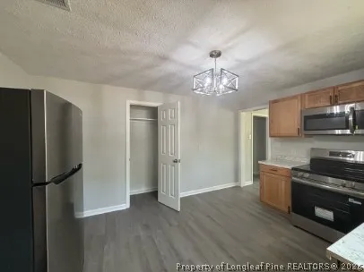 a kitchen with stainless steel appliances granite countertop a refrigerator and a stove top oven