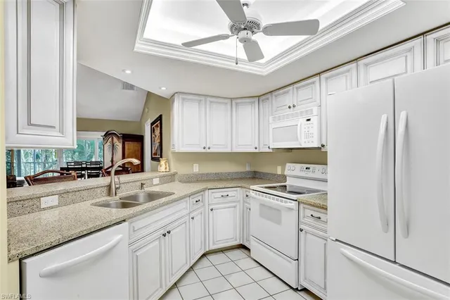 a kitchen with white cabinets and white appliances