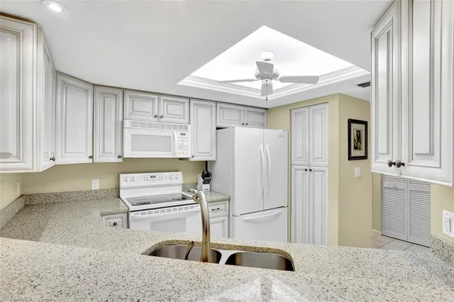 a kitchen with stainless steel appliances kitchen island granite countertop a refrigerator and a sink