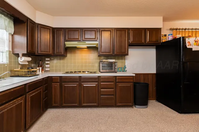 a kitchen with stainless steel appliances granite countertop wooden cabinets a sink and a window