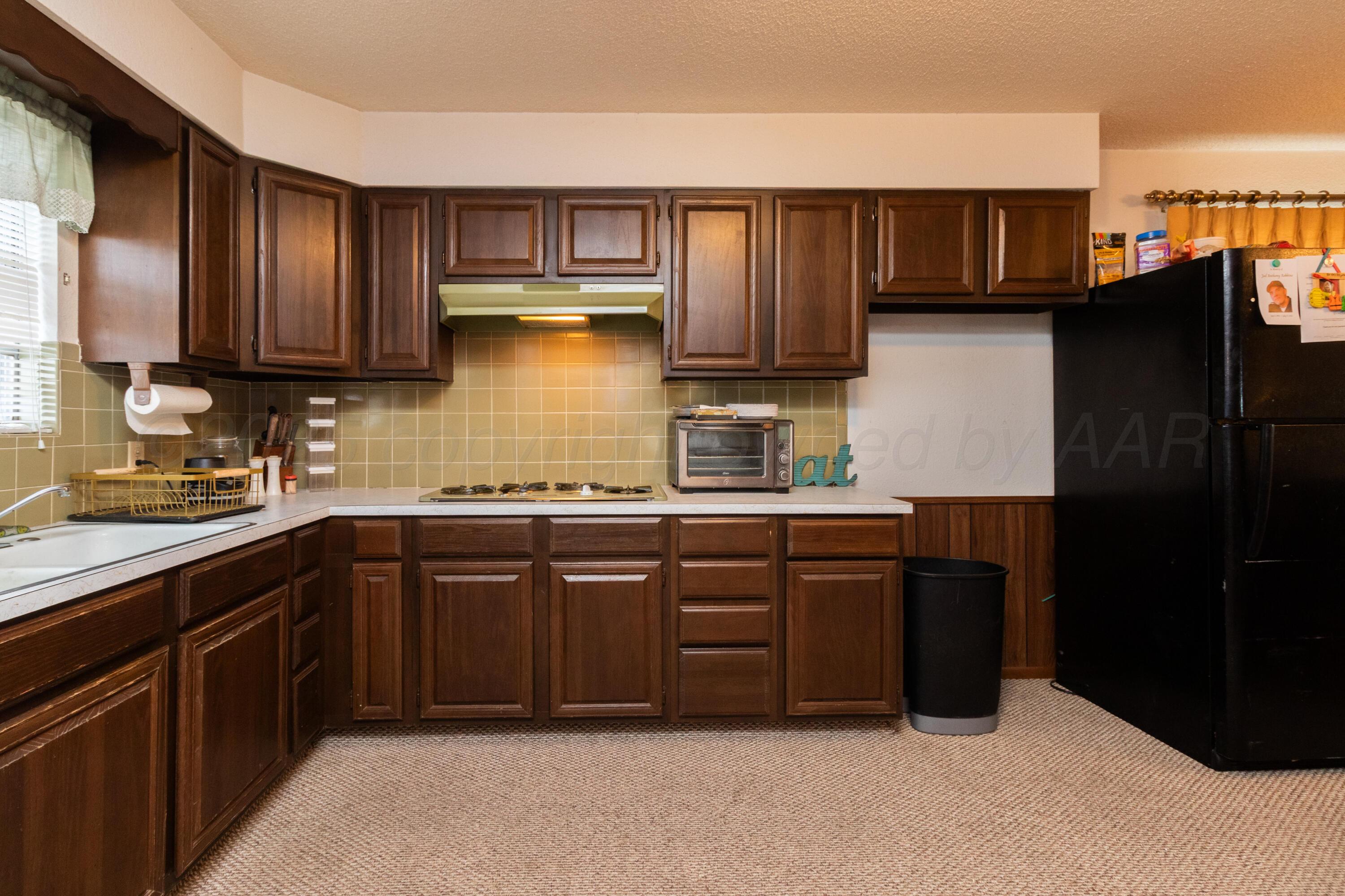 103 Jefferson Street Skellytown, TX 79080 - Photo 13 of 35 a kitchen with stainless steel appliances granite countertop a refrigerator and cabinets
