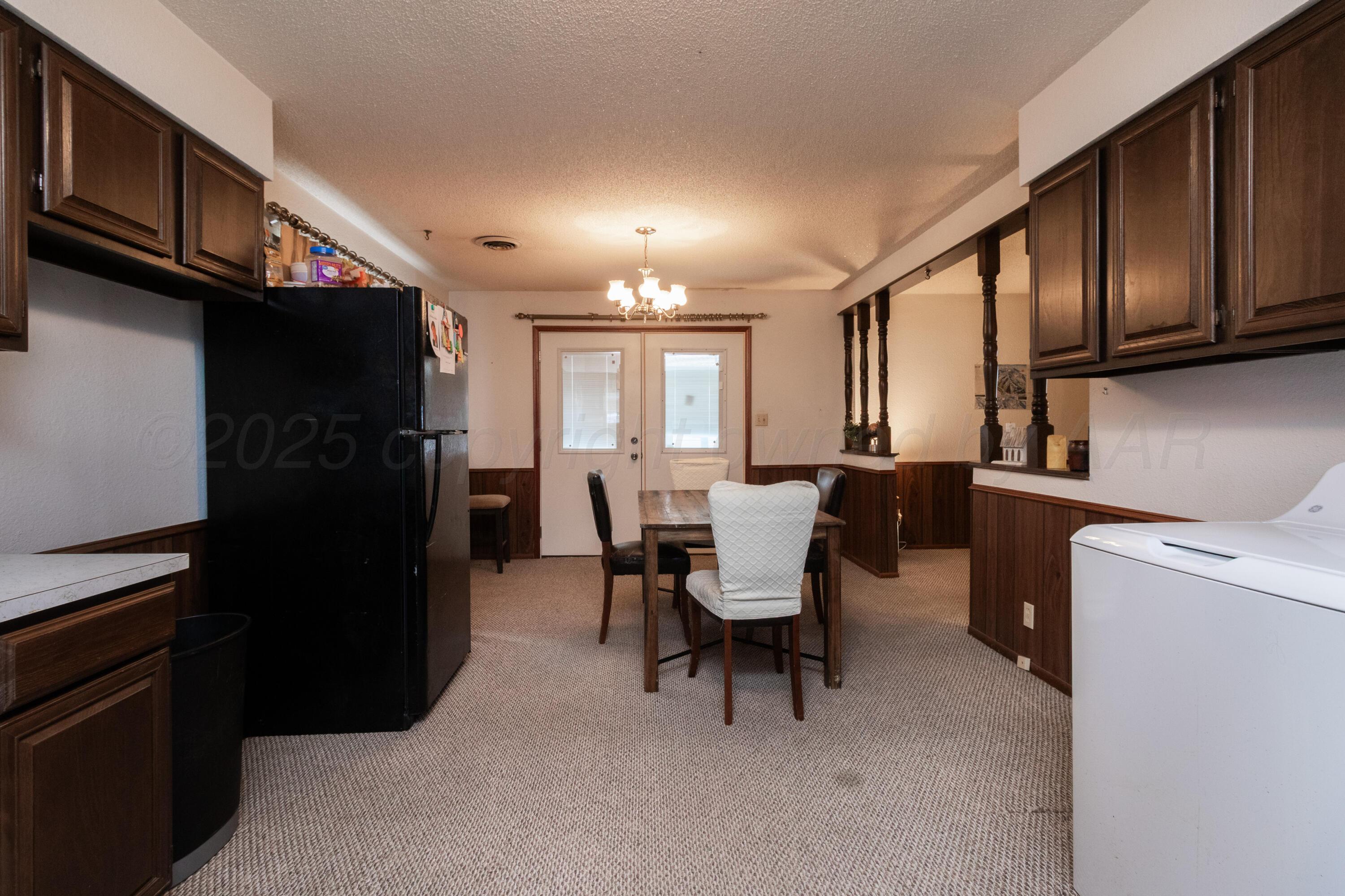 103 Jefferson Street Skellytown, TX 79080 - Photo 16 of 35 a kitchen with a table chairs refrigerator and cabinets