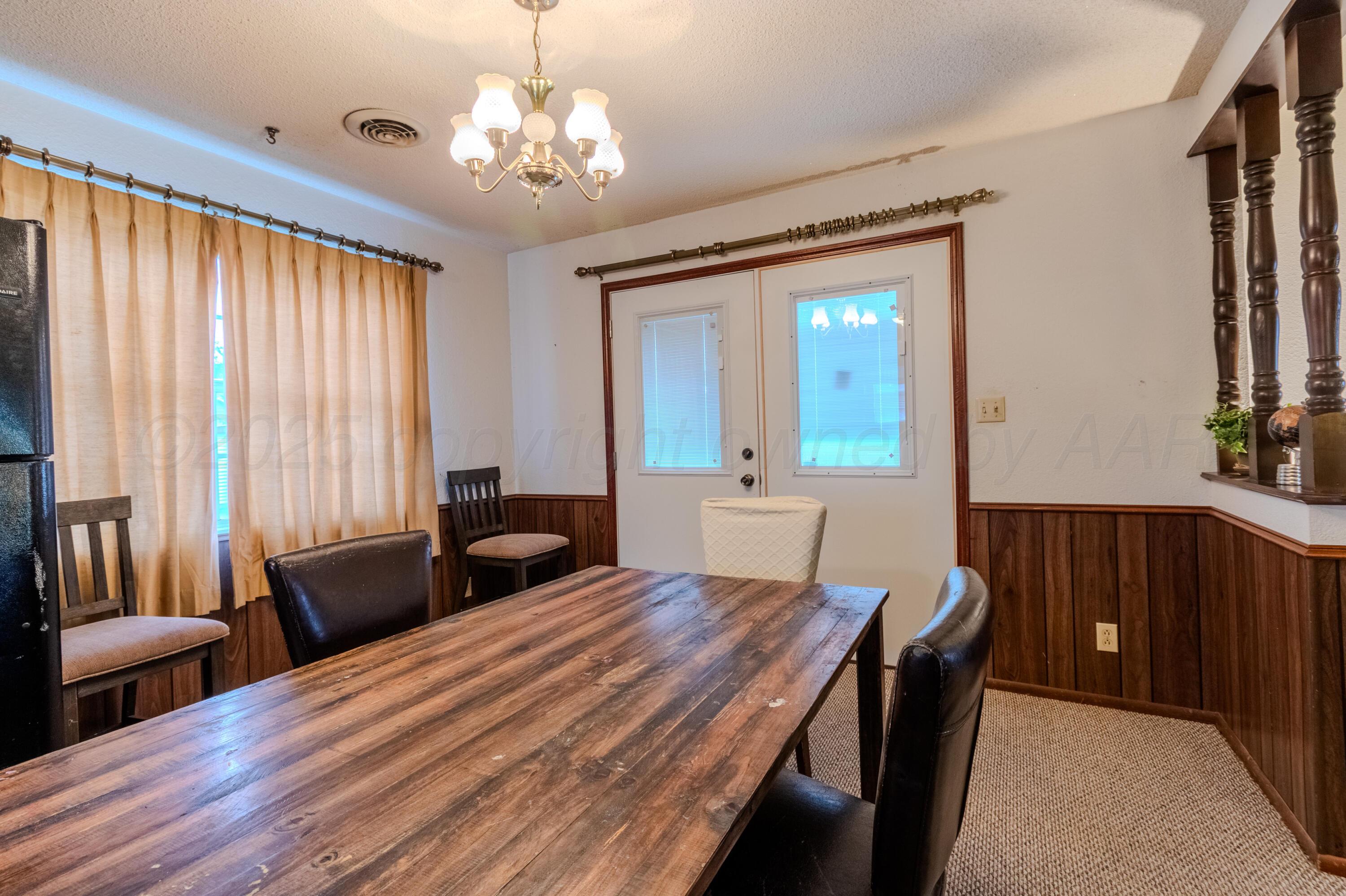 103 Jefferson Street Skellytown, TX 79080 - Photo 17 of 35 a bedroom with a large bed and a chandelier