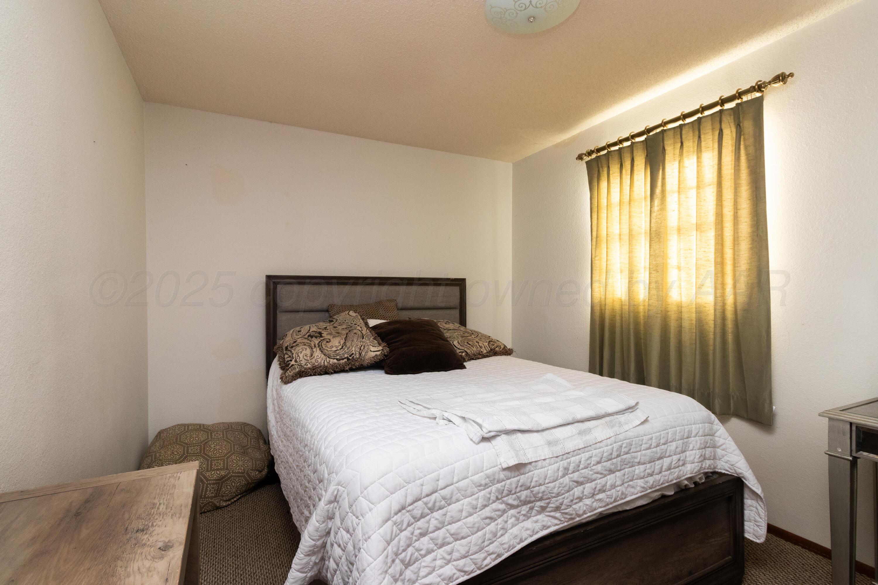 103 Jefferson Street Skellytown, TX 79080 - Photo 18 of 35 a bedroom with a bed and a window