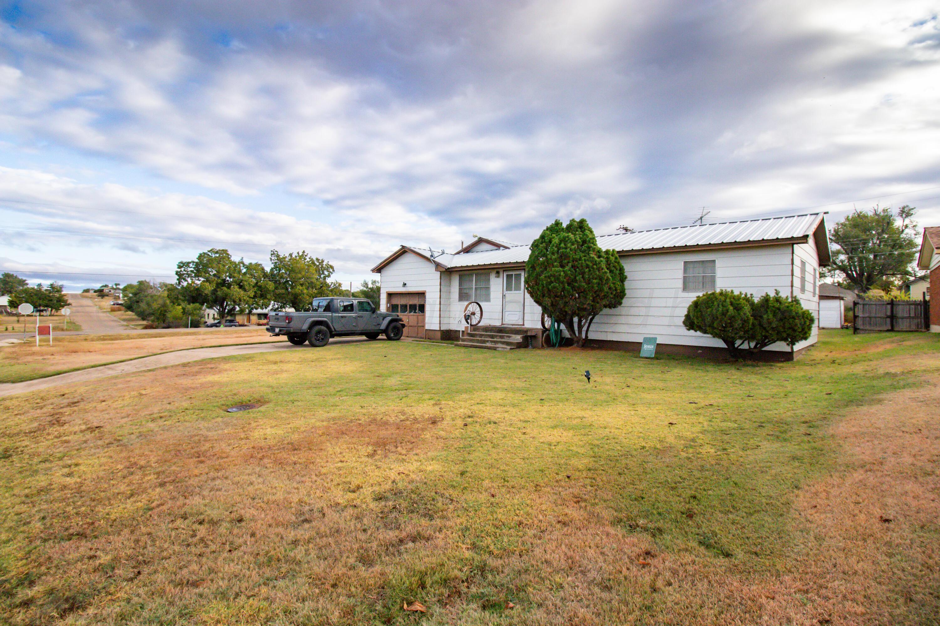 103 Jefferson Street Skellytown, TX 79080 - Photo 2 of 35 a house view with swimming pool and yard in front of it