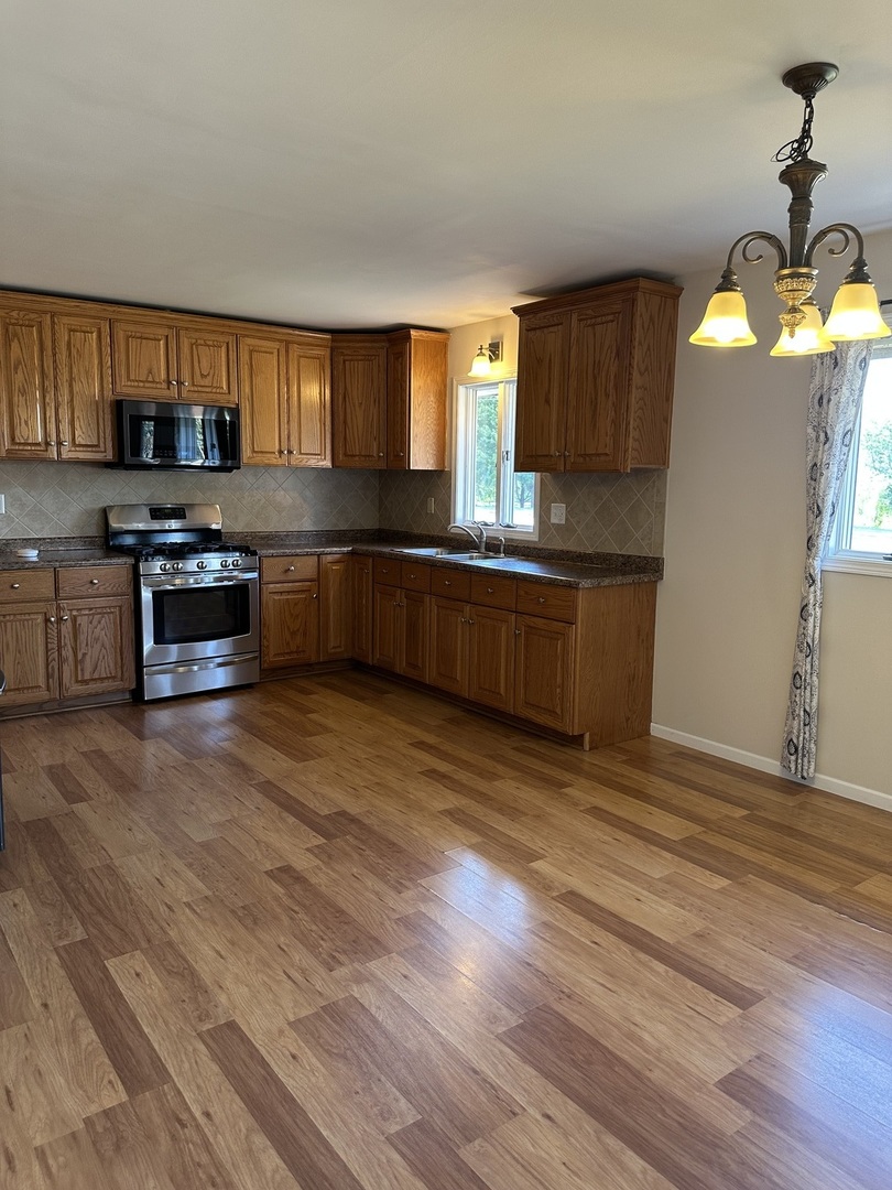1691 Bilter Road Aurora, IL 60502 - Photo 5 of 19 a kitchen with stainless steel appliances granite countertop a stove a sink and a refrigerator
