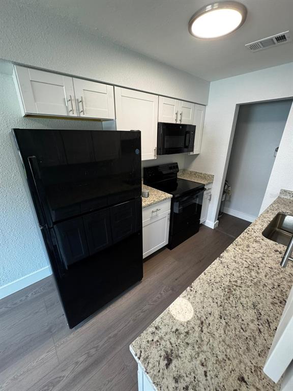 836 Southwest 64th Terrace, Unit B Gainesville, FL 32607 - Photo 7 of 13 a living room with stainless steel appliances kitchen island granite countertop a refrigerator stove and wooden floor