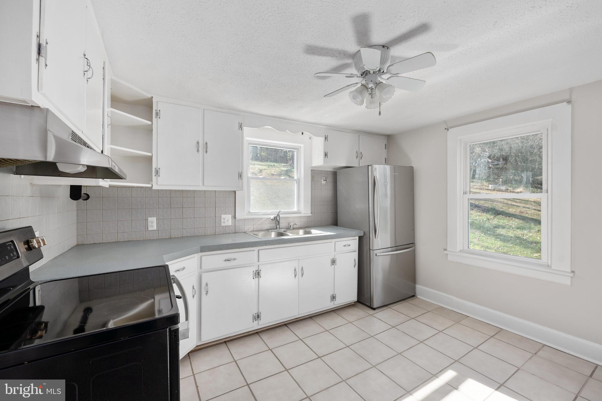 246 Berry Street Orange, VA 22960 - Photo 32 of 46 a kitchen with stainless steel appliances a sink a stove a refrigerator cabinets and a window
