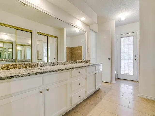 a bathroom with double sink and a mirror