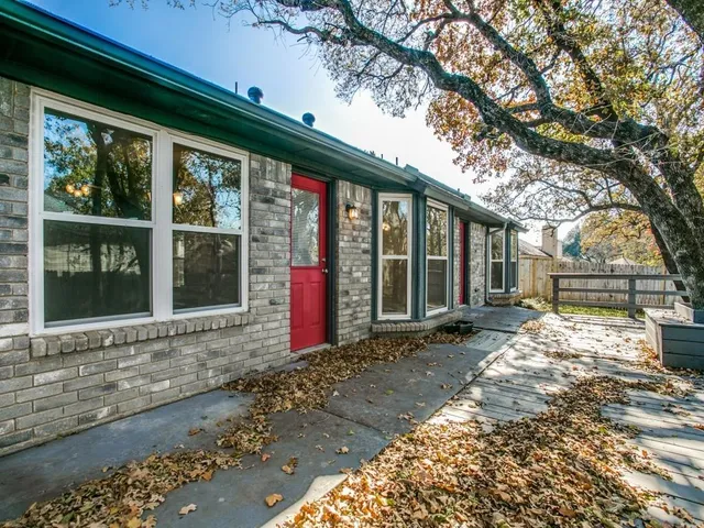 a view of a house with a large window and plants