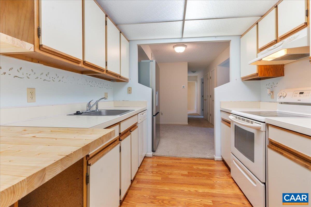 113 Turtle Creek Road, Unit 6 Charlottesville, VA 22901 - Photo 4 of 33 a kitchen with stainless steel appliances granite countertop a sink and dishwasher a stove with wooden floor
