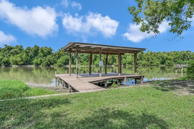 a view of a lake with a big yard and a large tree