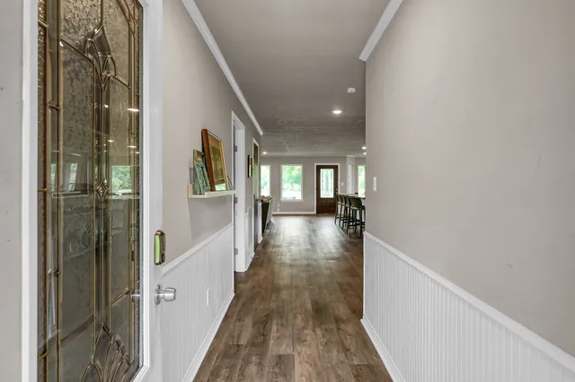 a view of a hallway with wooden floor and staircase