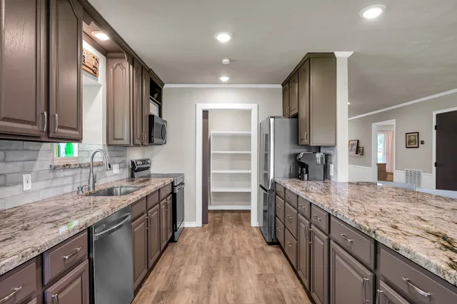 a kitchen with stainless steel appliances granite countertop a sink stove and refrigerator