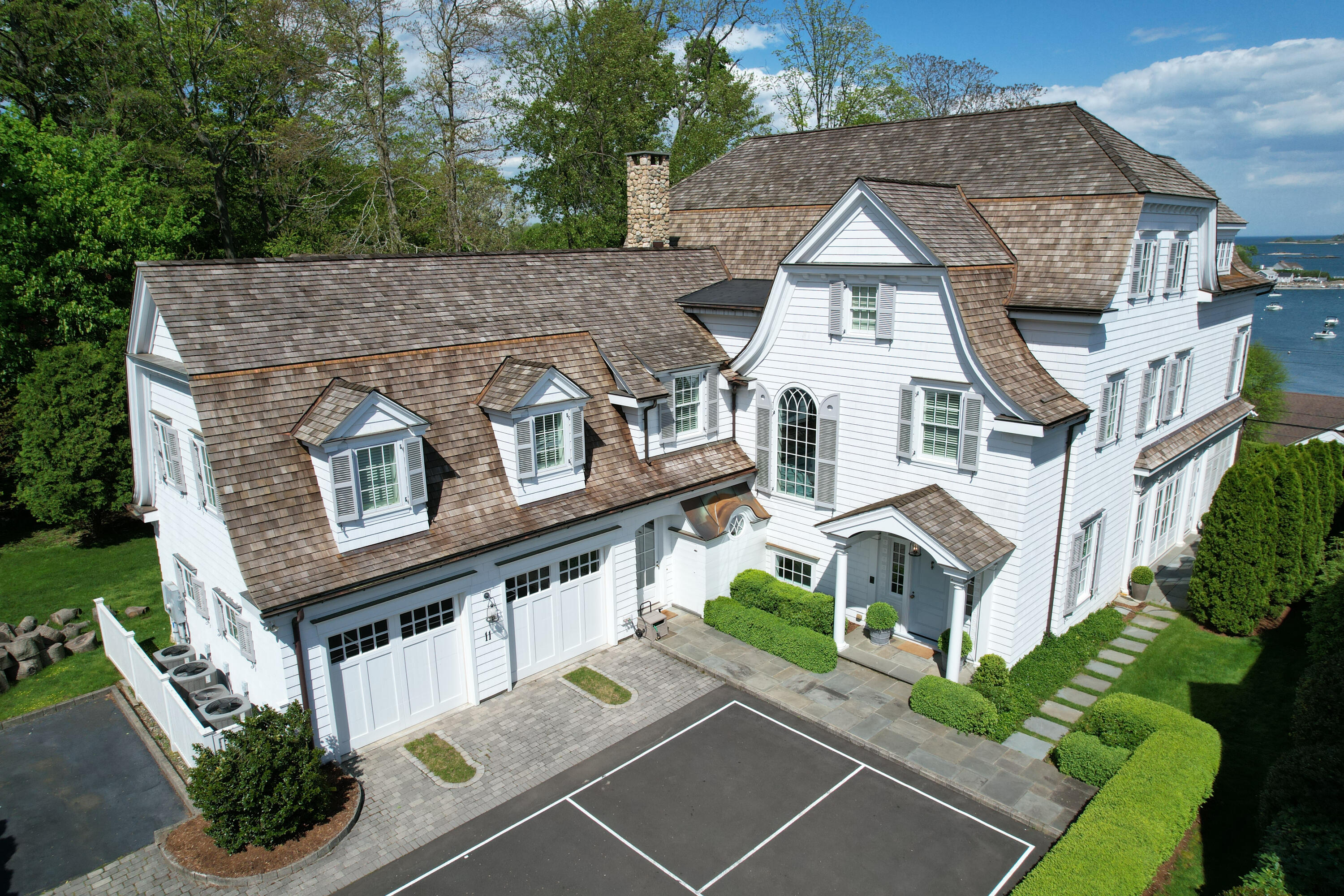11 Harbor Bluff Lane Rowayton, CT 06853 - Photo 2 of 31 a view of a white house with large windows and a small yard