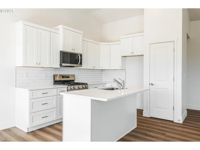 a kitchen with stainless steel appliances a stove microwave and cabinets