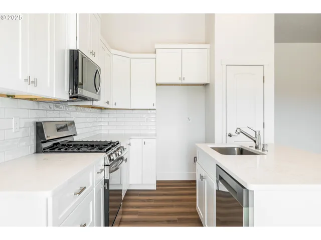 a kitchen with kitchen island a sink stove top oven and microwave