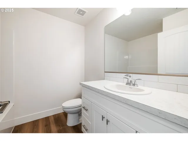 a bathroom with a granite countertop sink a toilet and a mirror