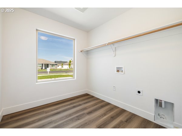 303 Sage Street Boardman, OR 97818 - Photo 2 of 25 a view of an empty room with wooden floor and a window