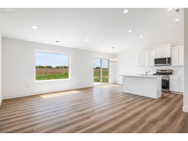 a view of kitchen with wooden floor electronic appliances and window