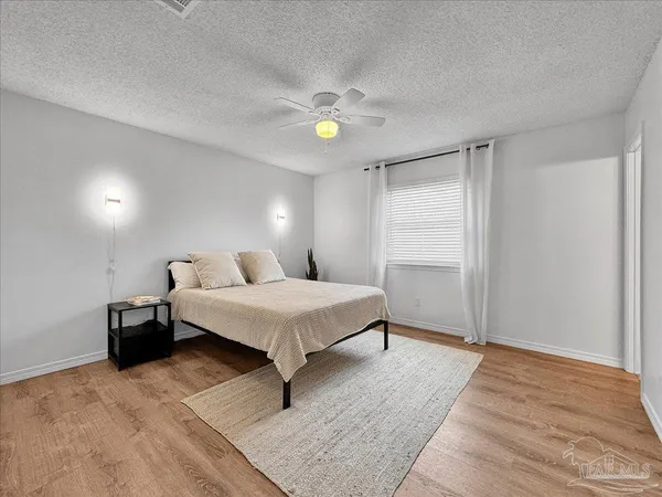 a spacious bedroom with a bed and a chandelier